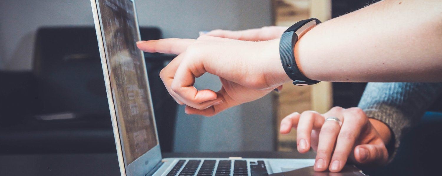 marketer pointing something out on a laptop screen